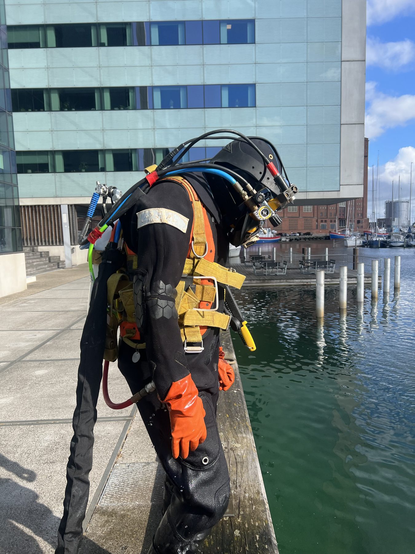 Erhvervsdykker i fuld udrustning ved et havnebassin